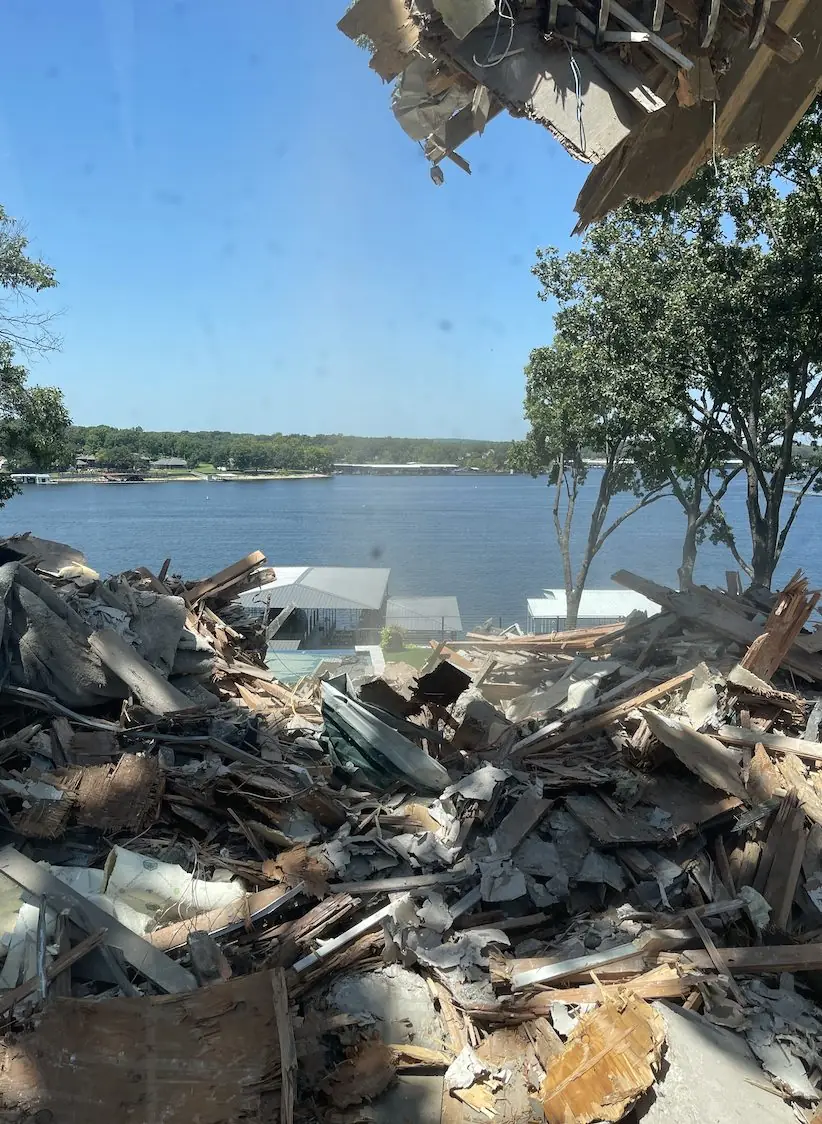 Pile of demolition debris, timber and metal sheeting, at a lakeside property