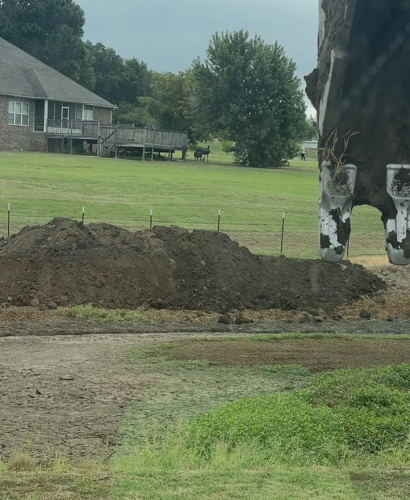 Spoil pile beside a yard next to a brick house